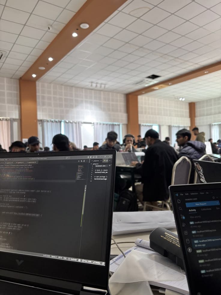 A coding workspace with laptops and people working together